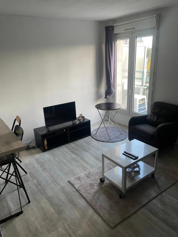 Évry-les-ChâteauxAppartement cosy en plein centre-ville的客厅配有沙发和桌子