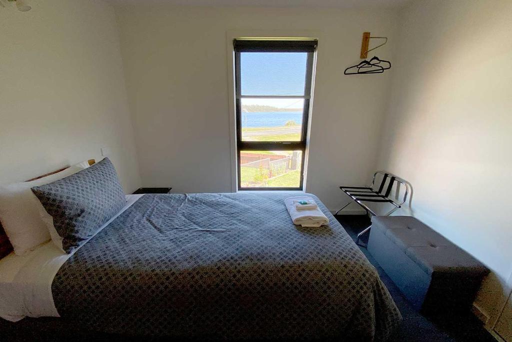 斯特拉恩Wild Rivers Escape的一间卧室设有一张床、一个窗口和一把椅子