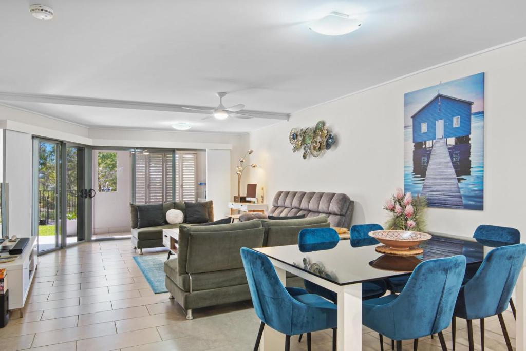 阿格奈什沃特Dream Time Direct Beach Access的客厅配有桌子和蓝色椅子