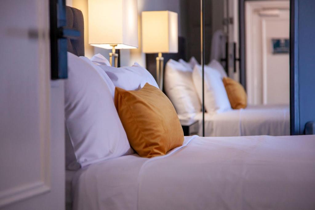 悉尼贝斯沃特精品旅馆 的卧室配有白色的床、枕头和镜子