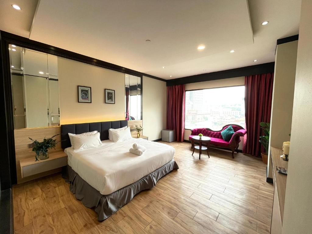 吉隆坡Kingston Hotel Kuala Lumpur的卧室配有一张白色大床和一把椅子