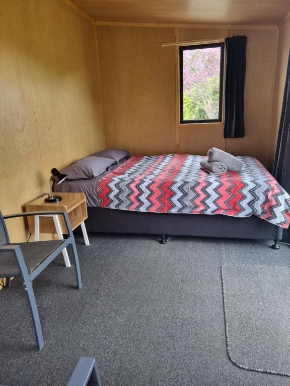 默奇森Murchison Motorhome Park的一间卧室配有一张床、一张桌子和一个窗户。