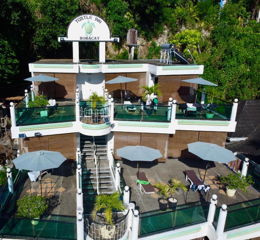 长滩岛乌龟客栈度假村的享有大楼空中美景,配有桌子和伞