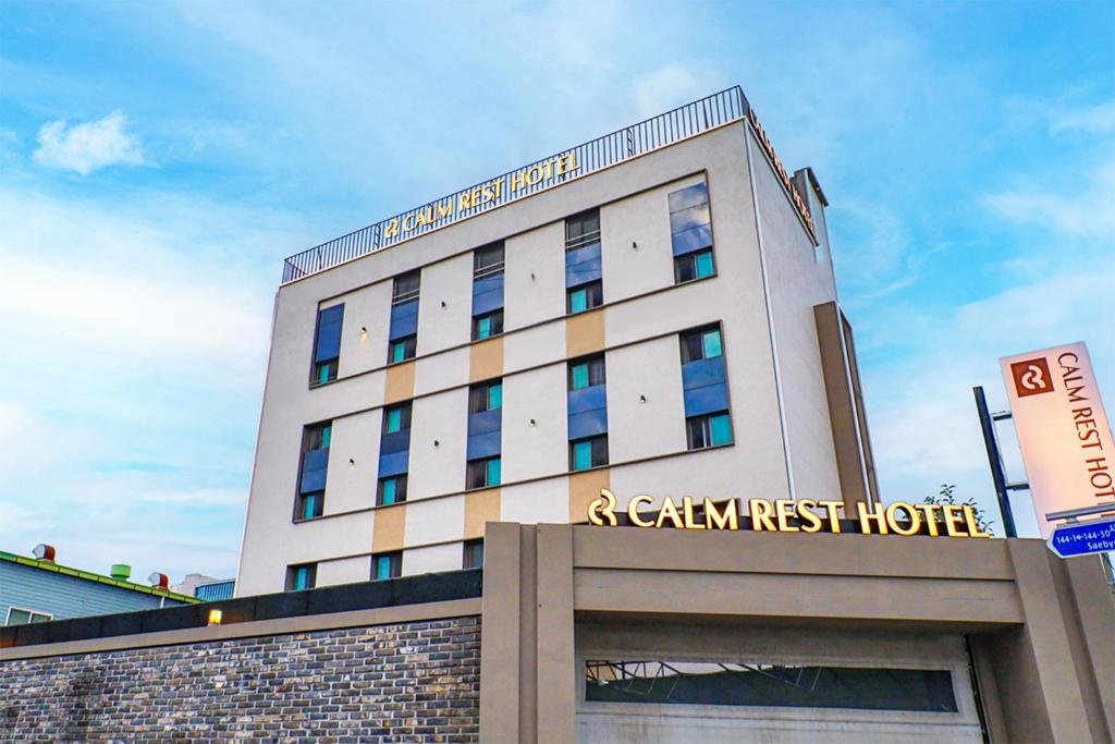 釜山Calm Rest Hotel Busan Sasang的前面有标志的建筑