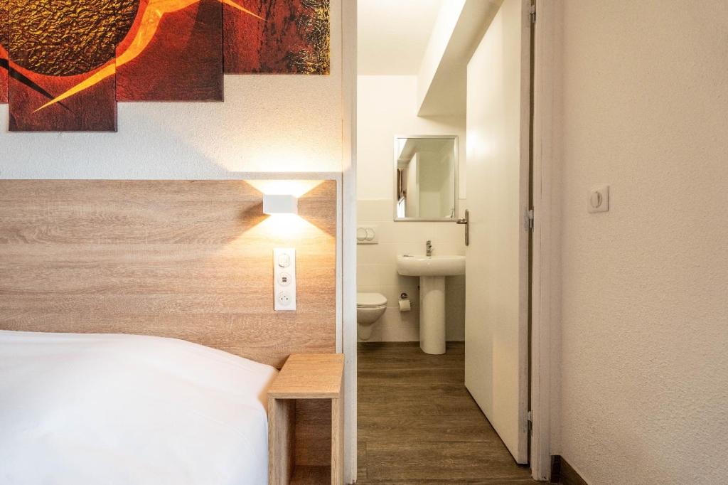 布里尼奥勒KYRIAD DIRECT BRIGNOLES - Provence Verte的一间卧室配有一张床,浴室设有水槽