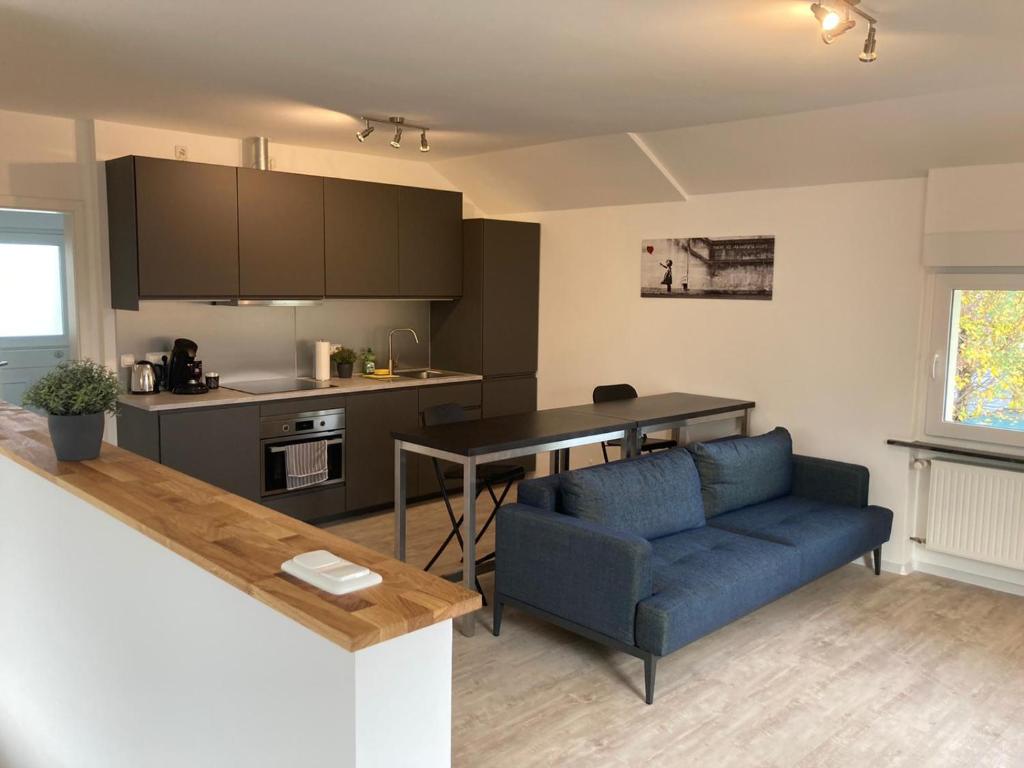 沃尔夫斯堡MEINpartments - Full service living的一间带蓝色沙发的客厅和一间厨房