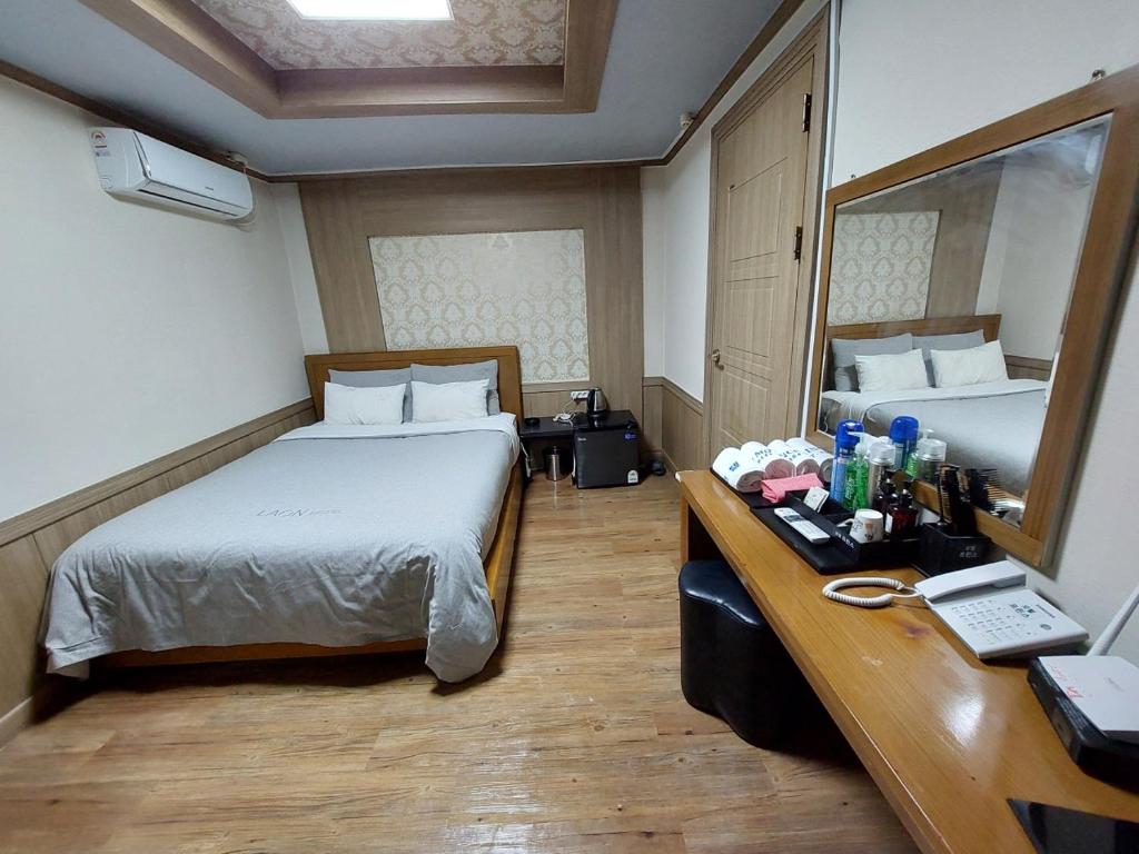 釜山Prince Motel的酒店客房配有一张床和一张带镜子的书桌