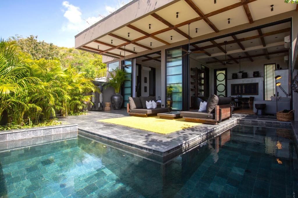 苏梅岛Clay Hut 2 Bedroom Luxury Villa的一个带游泳池和房子的户外起居区