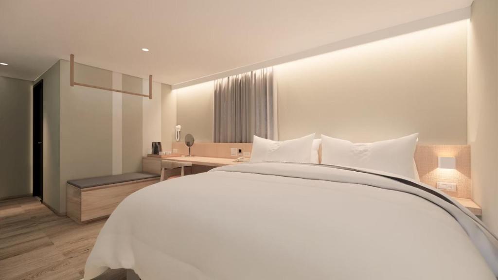 台南大立大饭店的卧室配有一张白色大床和一张书桌
