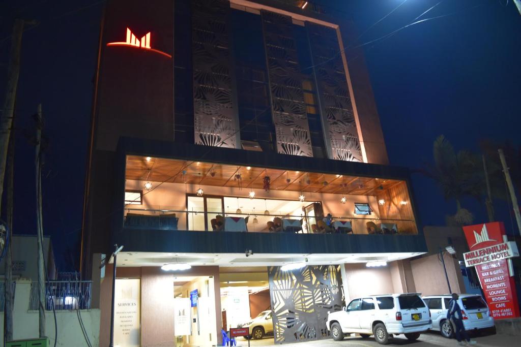 坎帕拉Millennium Terrace Hotel的一座建筑物,上面有夜间标志