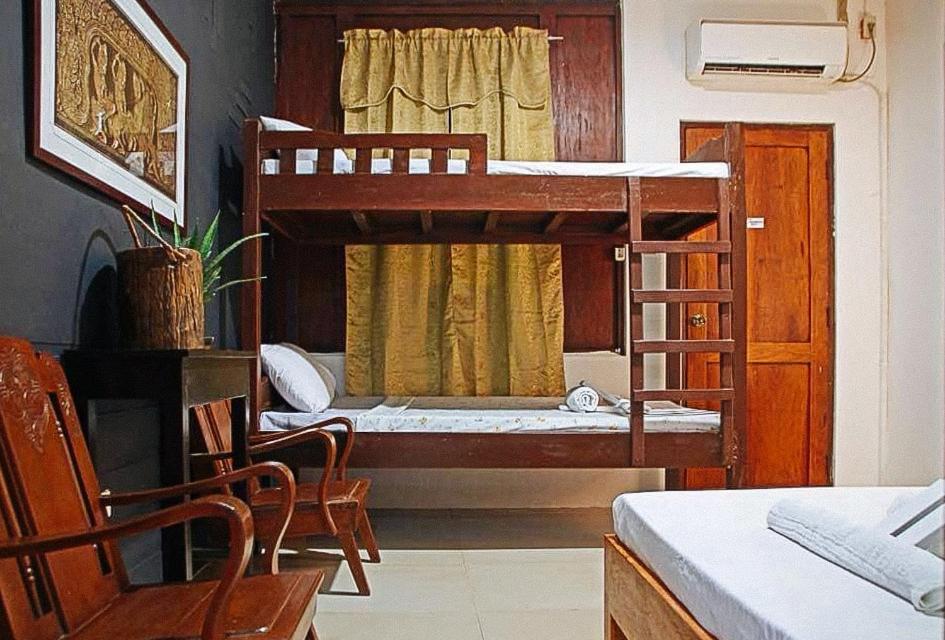 BantaoayRedDoorz Hostel @ Deomar Hometel & Farm Cafe Ilocos Sur的一间卧室配有一张双层床、一张桌子和一把椅子