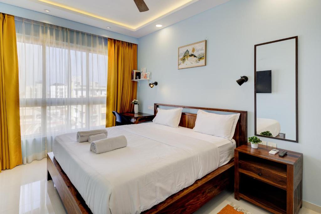 瓦斯科达伽马Coral BnB Premium 2 BHK Apartment - 5 km from Dabolim Airport的一间卧室设有一张大床和一个大窗户