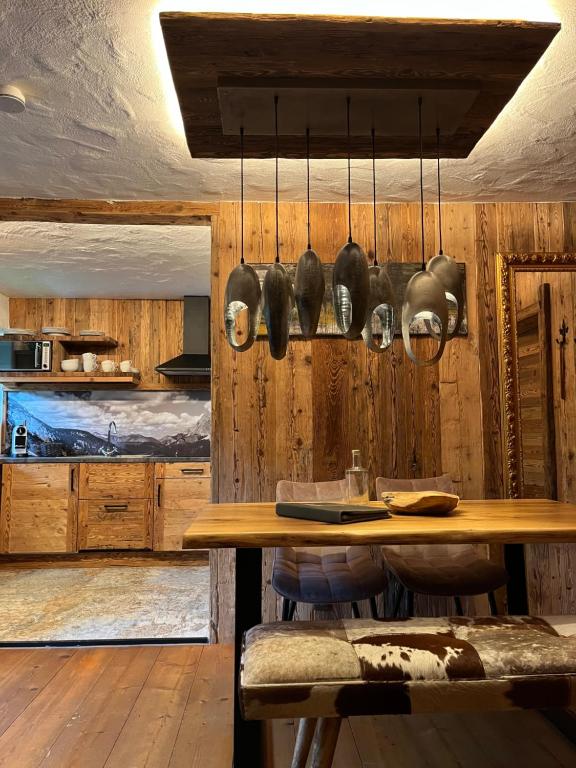 埃尔瓦尔德Chalet Apart Hansler的厨房配有木墙、桌子和餐具