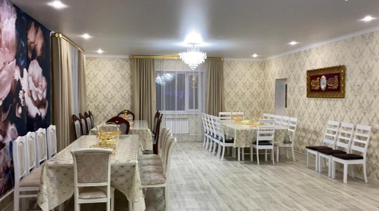 博罗沃耶Коттедж的一间带桌椅和吊灯的用餐室