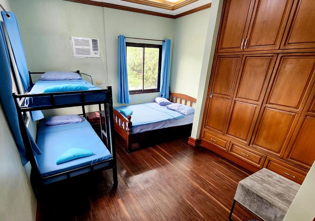 TanauanLeynes Taal Lake Resort and Hostel的客房设有两张双层床和一扇窗户。