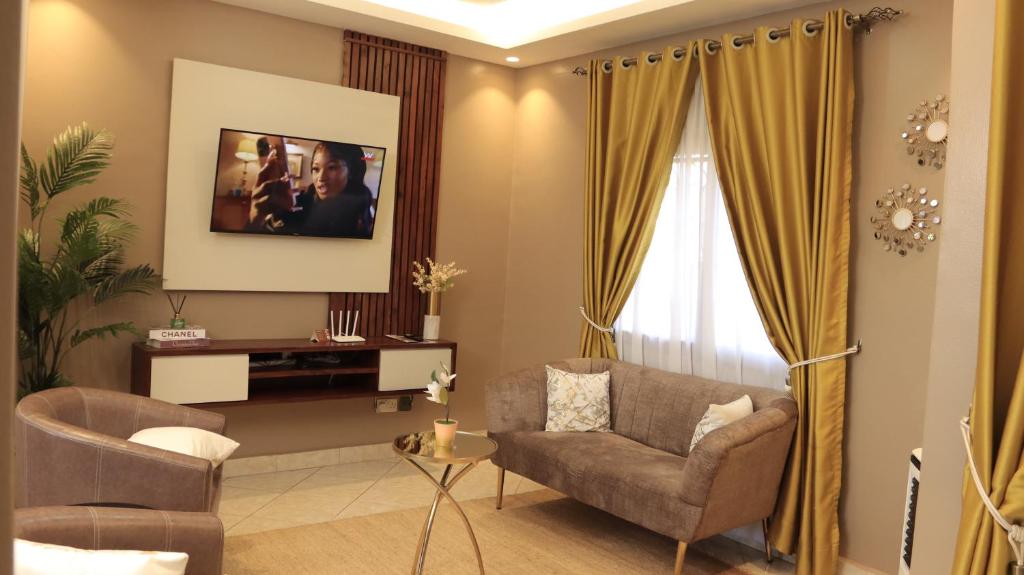 坎帕拉Premier Suites Kyanja的客厅配有沙发和椅子