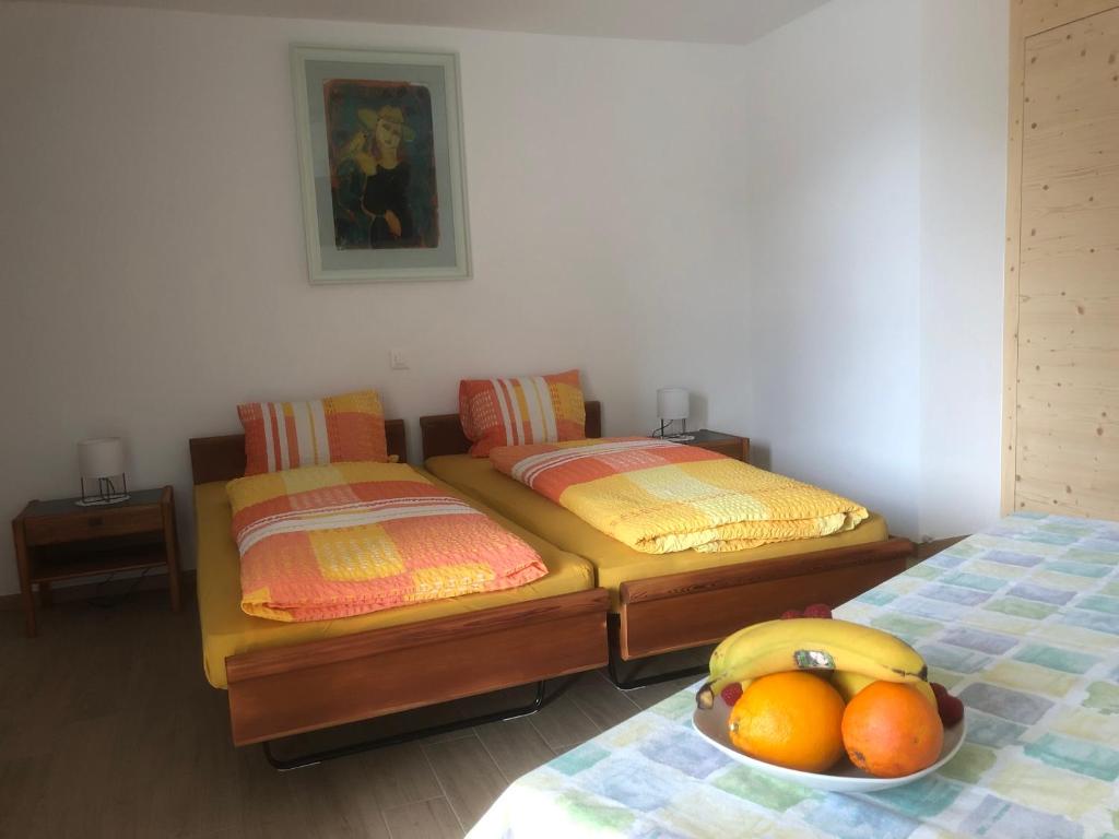 乐普斯B&B Alpina的客房内的两张单人床和一碗水果