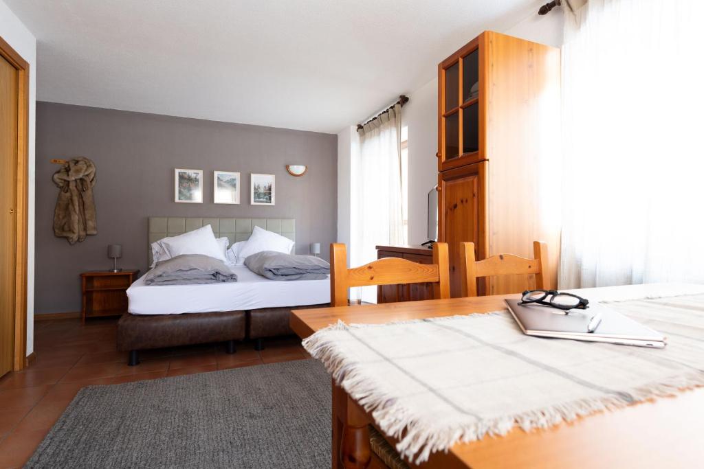 圣卡特琳娜瓦尔夫Chalet Ginepro的一间卧室配有两张床、一张桌子和一张桌子