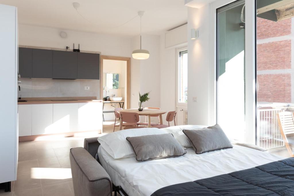 梅莱尼亚诺New Exclusive Melegnano Apartments- Near train station的一间卧室配有一张床,厨房配有桌子