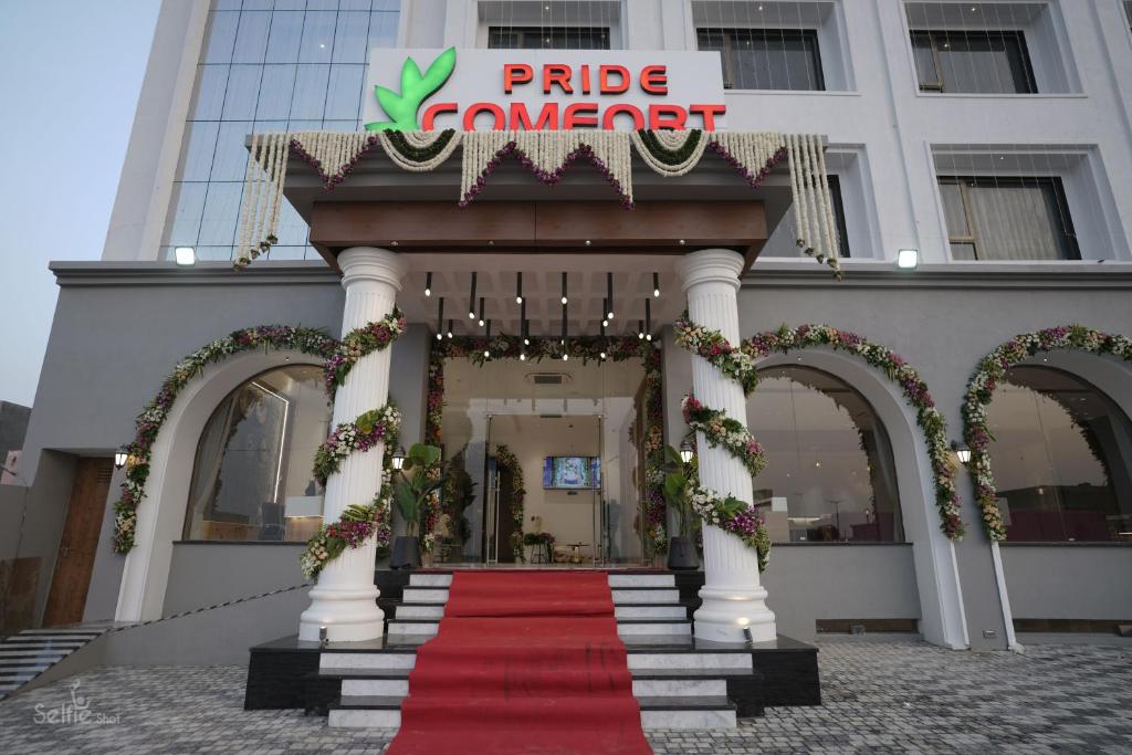 德瓦尔卡Pride Comfort Dwarka的红地毯和大楼的酒店入口