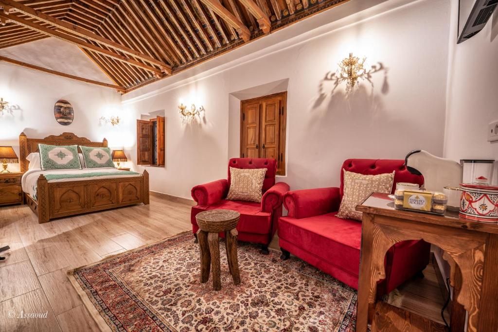舍夫沙万Riad Dar Chama的客厅配有红色的沙发和床。
