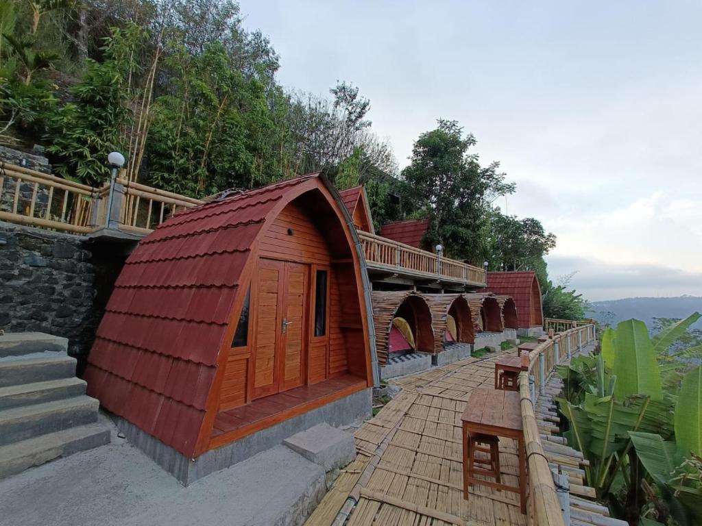 金塔马尼The Panorama Batur Camp的一座有红色屋顶和桥梁的建筑
