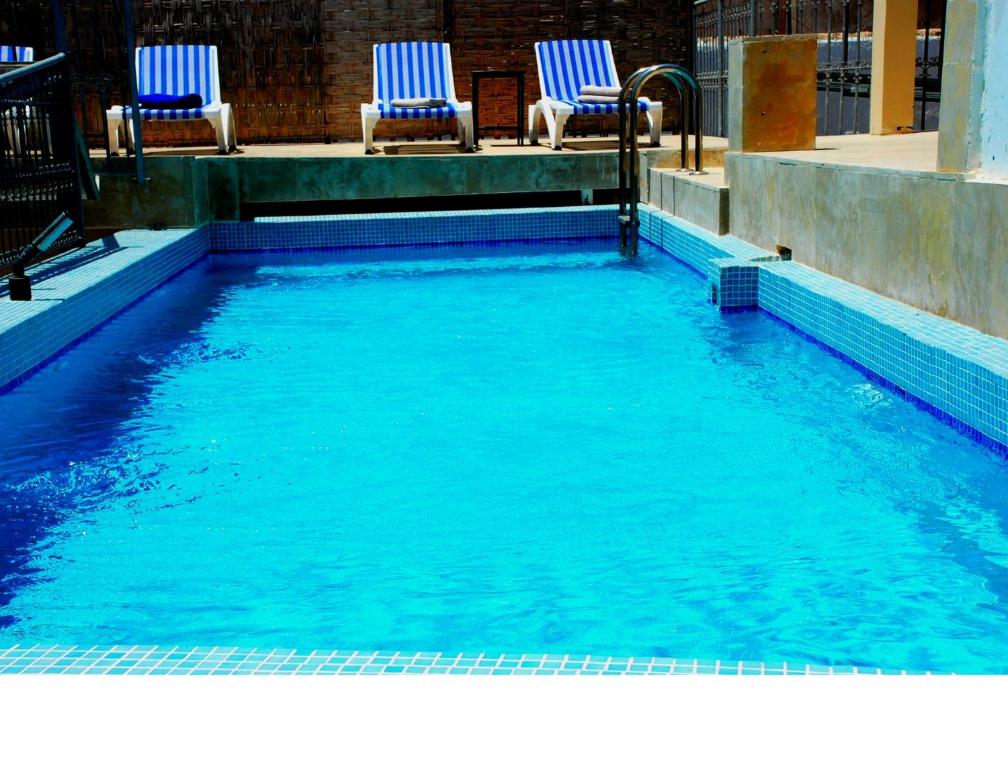 塞拉马尔科安达卢斯摩洛哥传统庭院住宅的游泳池设有两把蓝色椅子