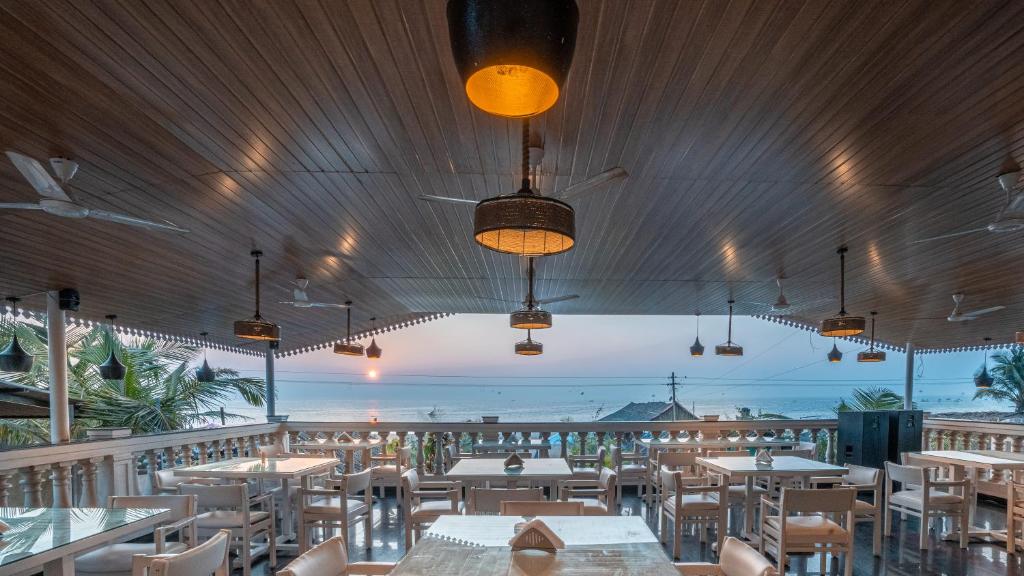 戈阿韦尔哈Lillywoods Zac Beach Resort, Calangute的一间带桌椅的海景餐厅