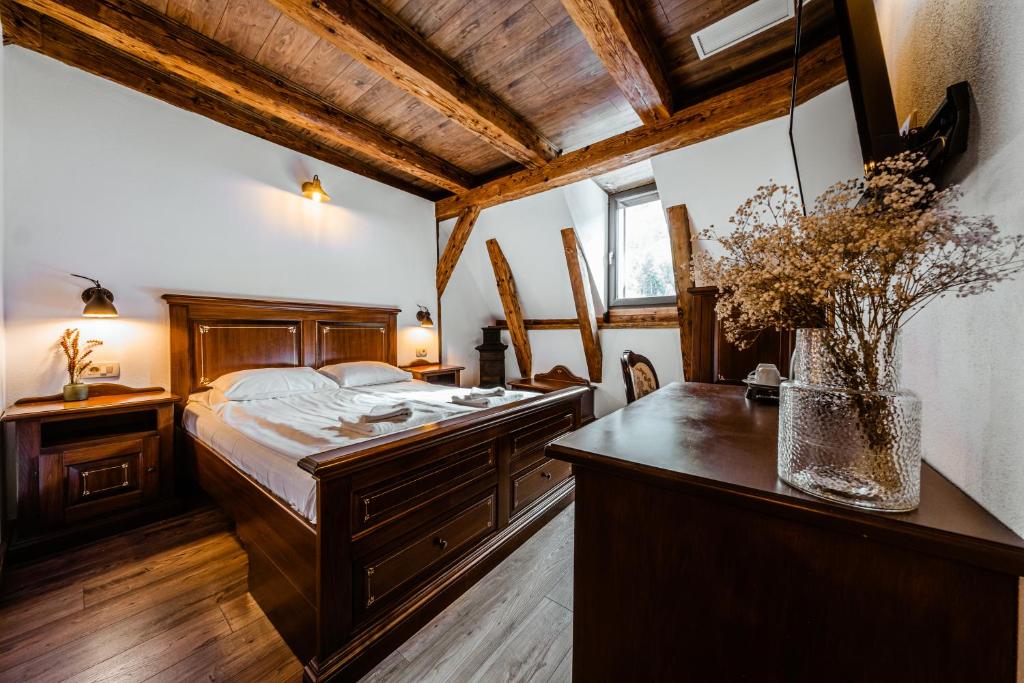 布拉索夫CASA CHITIC - HOTEL & RESTAURANT- Str Nicolae Balcescu 13的一间卧室配有一张床和一张带花瓶的书桌