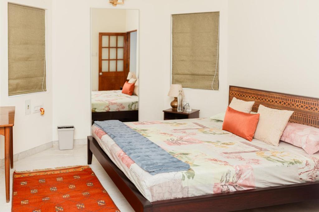 班加罗尔Luho 41 Penthouse的一间卧室配有一张带橙色枕头的大床