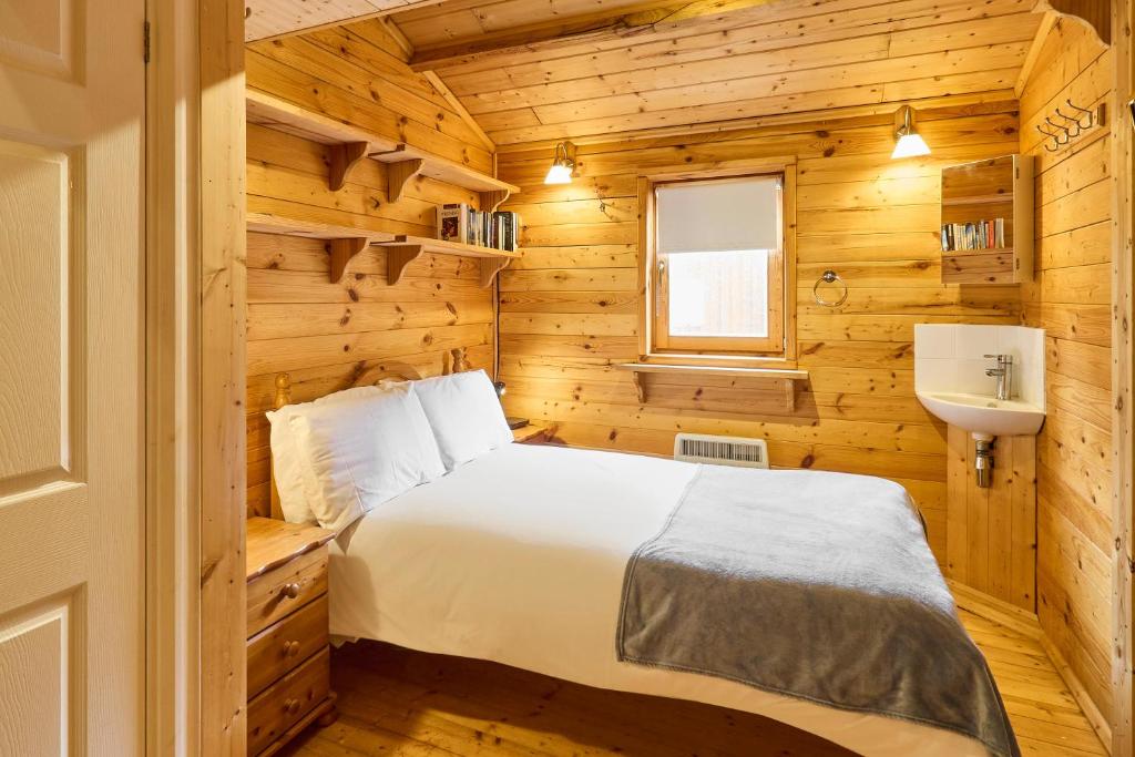 布罗德斯泰Host & Stay - Astoria的木制客房内的一间卧室配有一张床和一个水槽