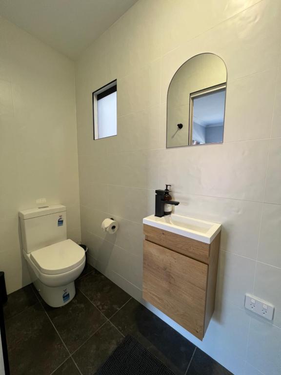 AdelongGold Reef Adelong的一间带卫生间、水槽和镜子的浴室