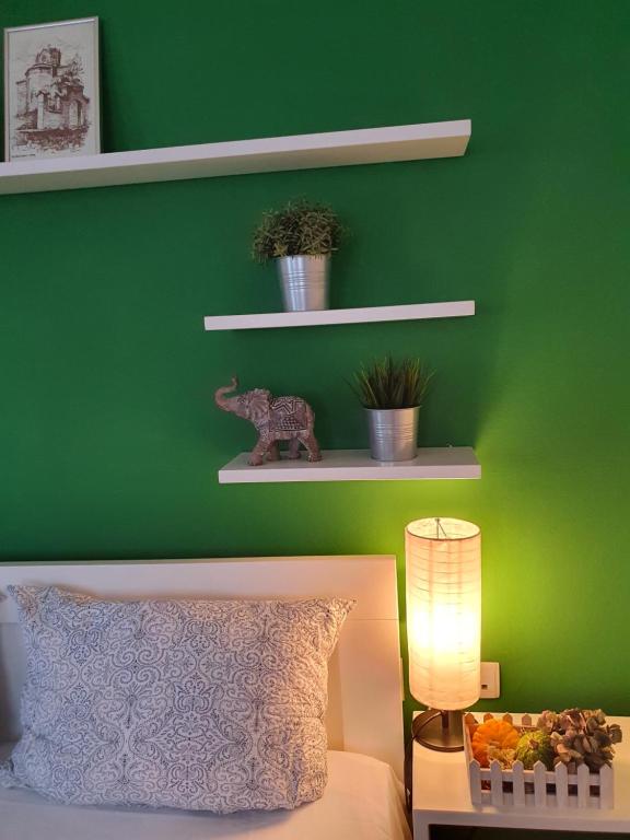 奥赫里德内拉公寓的绿色卧室,配有床和绿色的墙壁