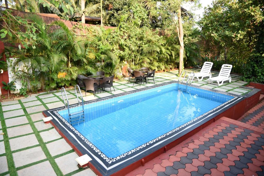 Moira4BHK Private Pool villa in North Goa and Kayaking nearby!!的一个带椅子的小游泳池