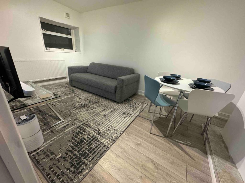 伦敦Apartment - Heart of London!的客厅配有沙发和桌椅