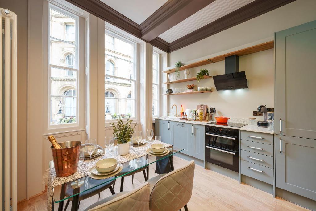 布里斯托The Florin - 1 Bedroom Apartment in Central Bristol by Mint Stays的厨房配有桌子和一些窗户。
