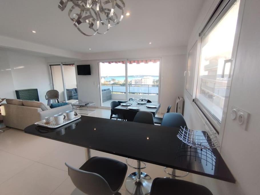 戛纳Cannes Vue mer T2 61m²+ parking的客厅配有大型黑桌和椅子