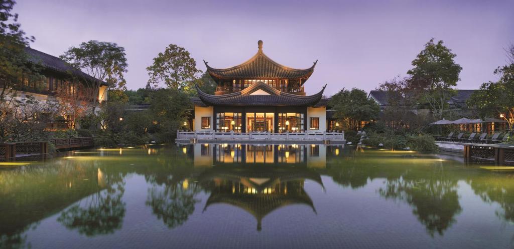 杭州杭州西子湖四季酒店的一座中国建筑,前面有一个池塘