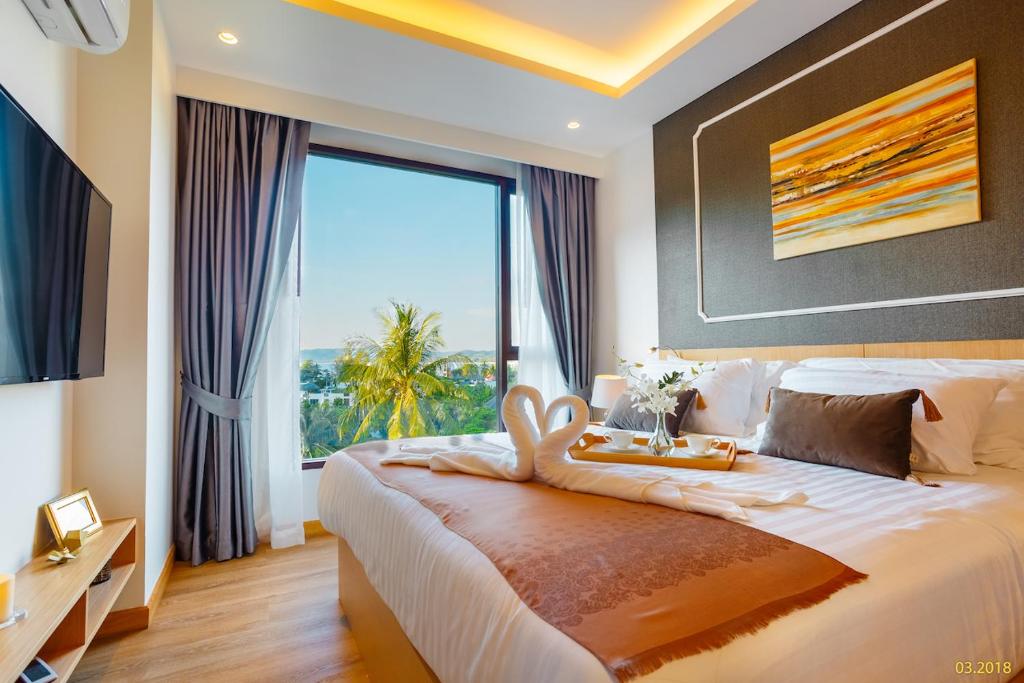 Ban Lum FuangAristo 2 Apartments by Beringela的一间卧室设有一张大床和大窗户