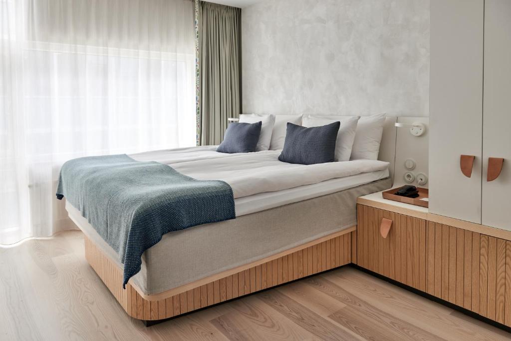斯德哥尔摩北欧之光酒店的一间卧室配有一张带蓝色枕头的大床