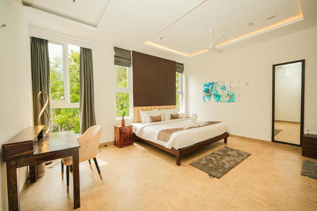 马哈巴利普拉姆Shelter Beach Resort的酒店客房配有一张床、一张书桌和一张书桌。