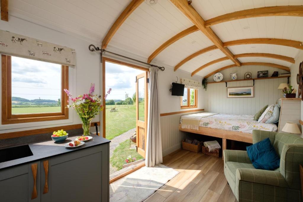 BradpoleThe Acorn - Luxury Shepherds Hut hot tub panoramic views的一间位于小房子的卧室,设有大窗户