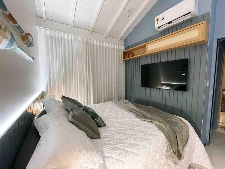 马塔迪圣若昂Praia do Forte Lodge的卧室配有一张床铺,墙上配有电视