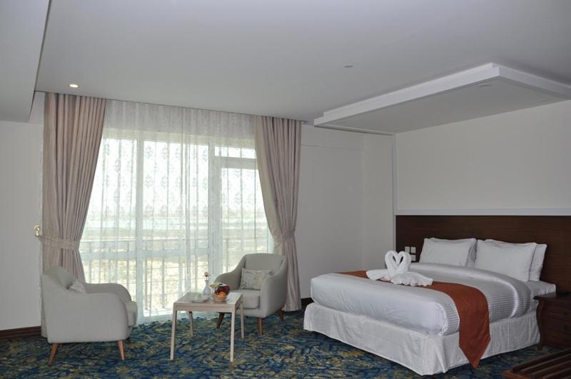 苏尔Sur Grand Hotel的一间设有大床和窗户的酒店客房