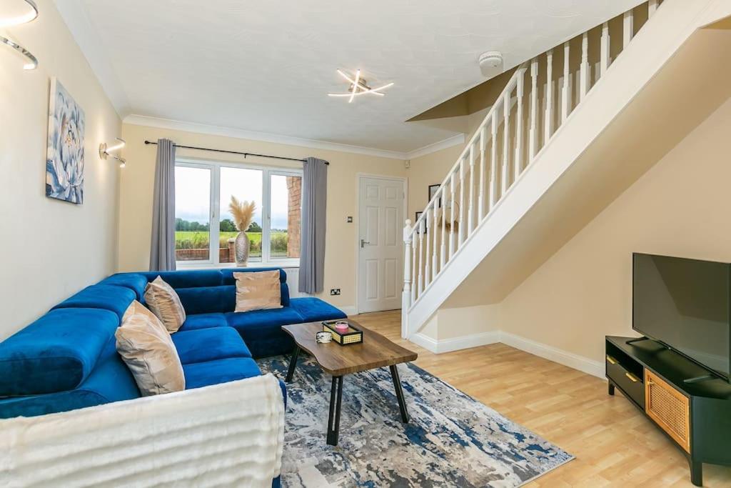 LincolnshireKime Contractor & Holiday Home的客厅配有蓝色的沙发和电视