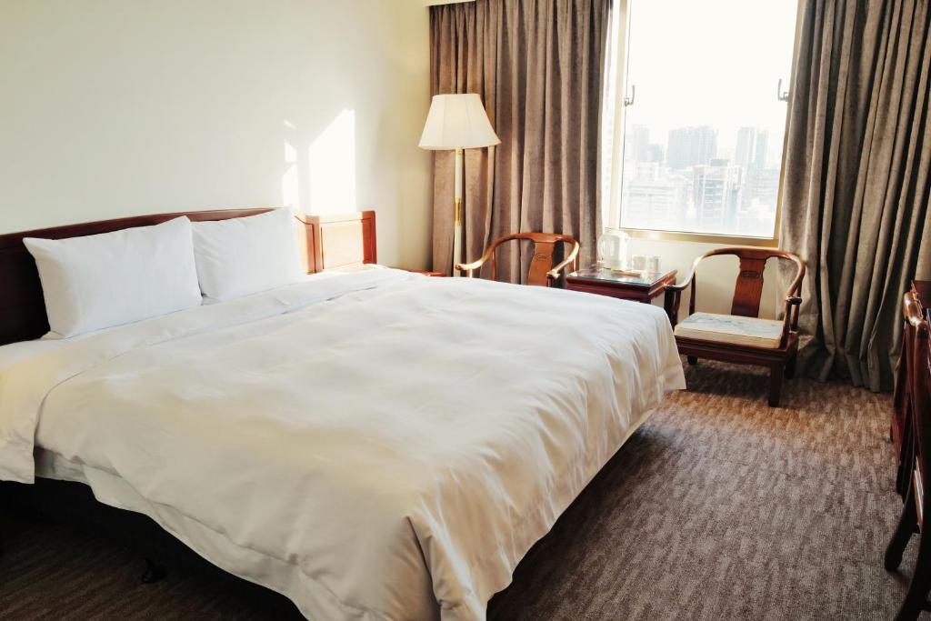 台中市T Hotel的酒店客房设有一张白色大床和一个窗户。