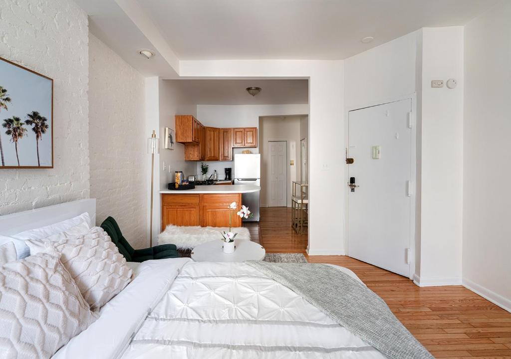 纽约Beautiful Studio Apartment At East Side的一间带白色床的客厅和一间厨房