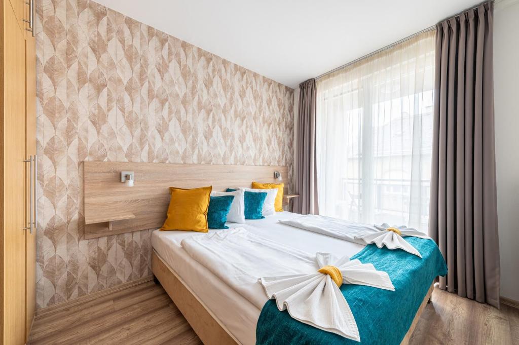 布达佩斯Nova Apartments的一间卧室配有蓝色和黄色枕头的床