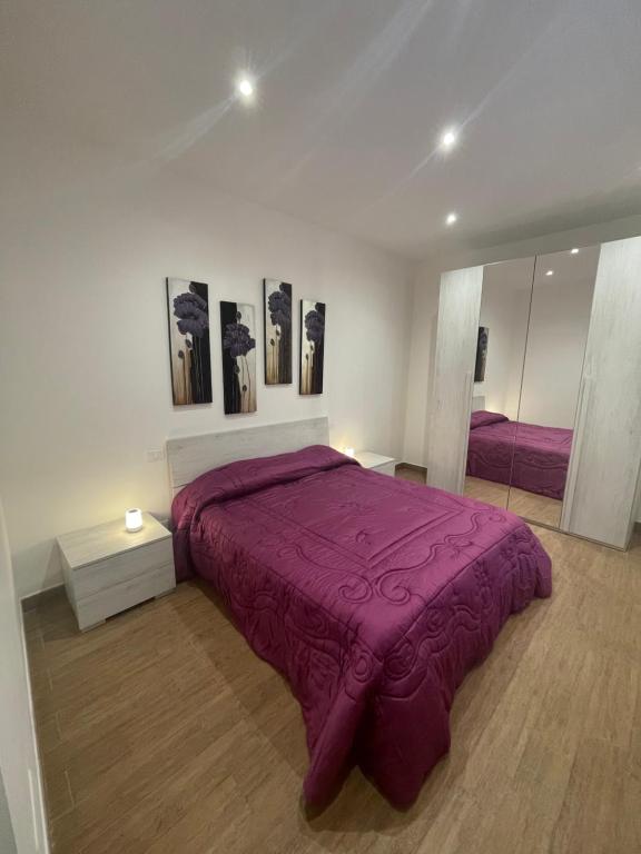 卡塞勒托瑞尼斯B&B L'Antico Portone的一间卧室配有一张紫色的床和镜子