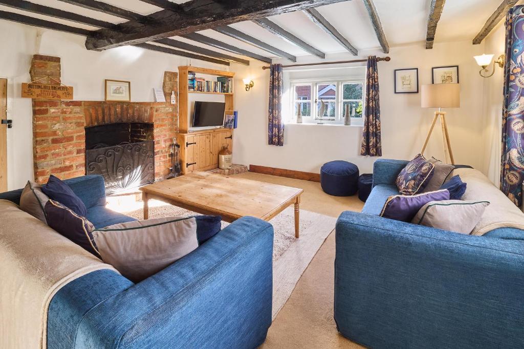 坎特伯雷Host & Stay - Bere Cottage的客厅配有2张蓝色沙发和壁炉
